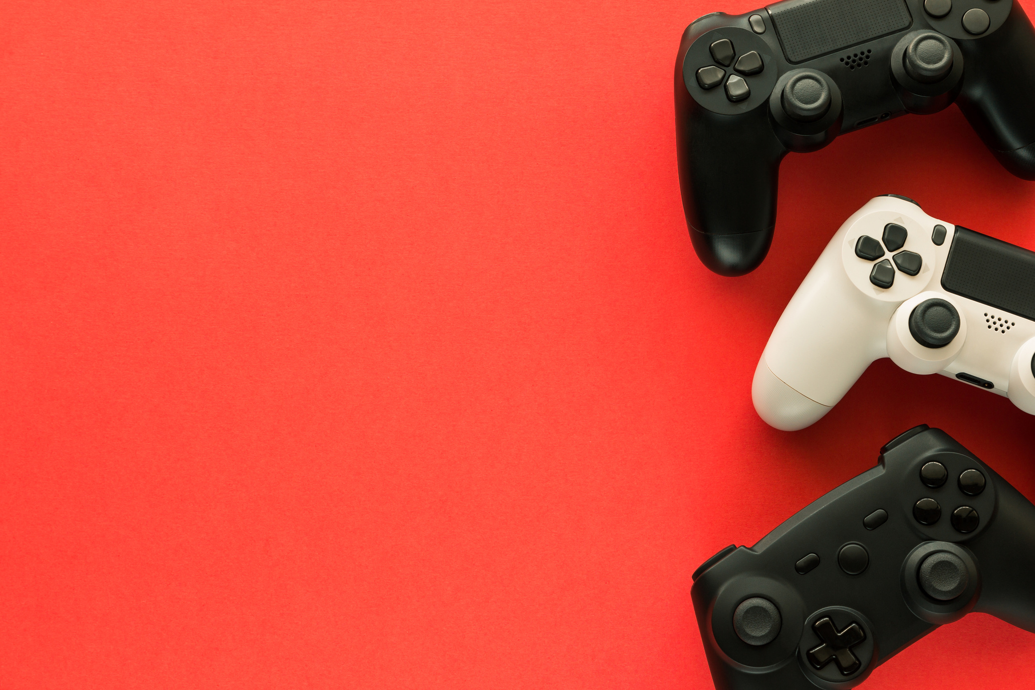 Stock Photo of Three Gamepads on a Red Background 